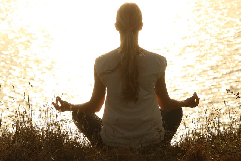 Woman practicing stillness meditation at sunset